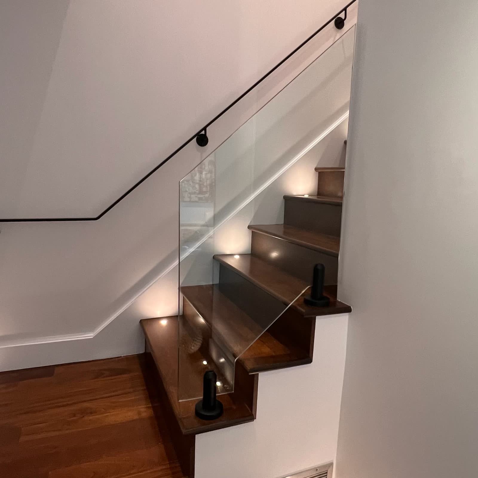 Escalier en noyer avec garde-corps en verre réalisé par Verre Magique